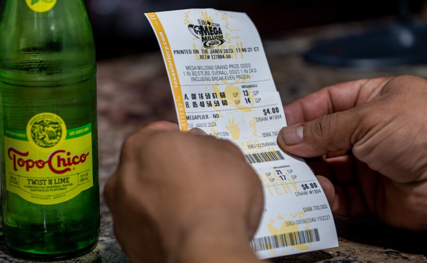 A customer looks at his lottery ticket at a CITGO gas station in Austin, Texas, on Jan. 10, as the Mega Millions jackpot climbed further above the $1 billion mark. The projected jackpot for Friday's drawing is $1.35 billion.
