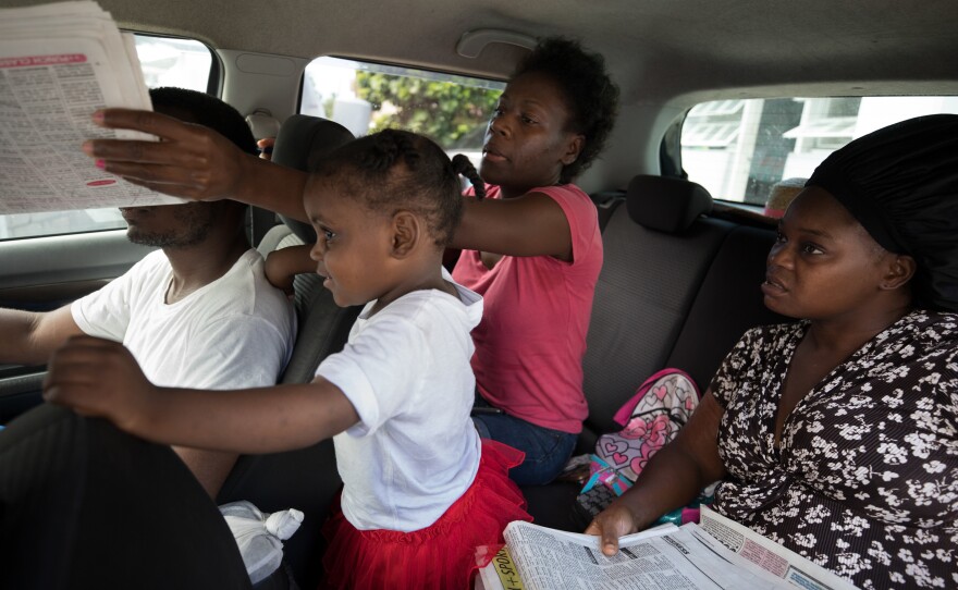 Evacuee Sherrine Petit Homme LaFrance (right) tries to find an apartment to rent in Nassau. She's being helped by family friends Benette Lutus (left) and Kenisher Lutus (center), who are with their 2-year-old daughter.