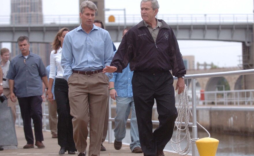 Minneapolis Mayor R.T. Rybak and President George W. Bush tour an area near a collapsed interstate bridge, which left 13 people dead in 2007.