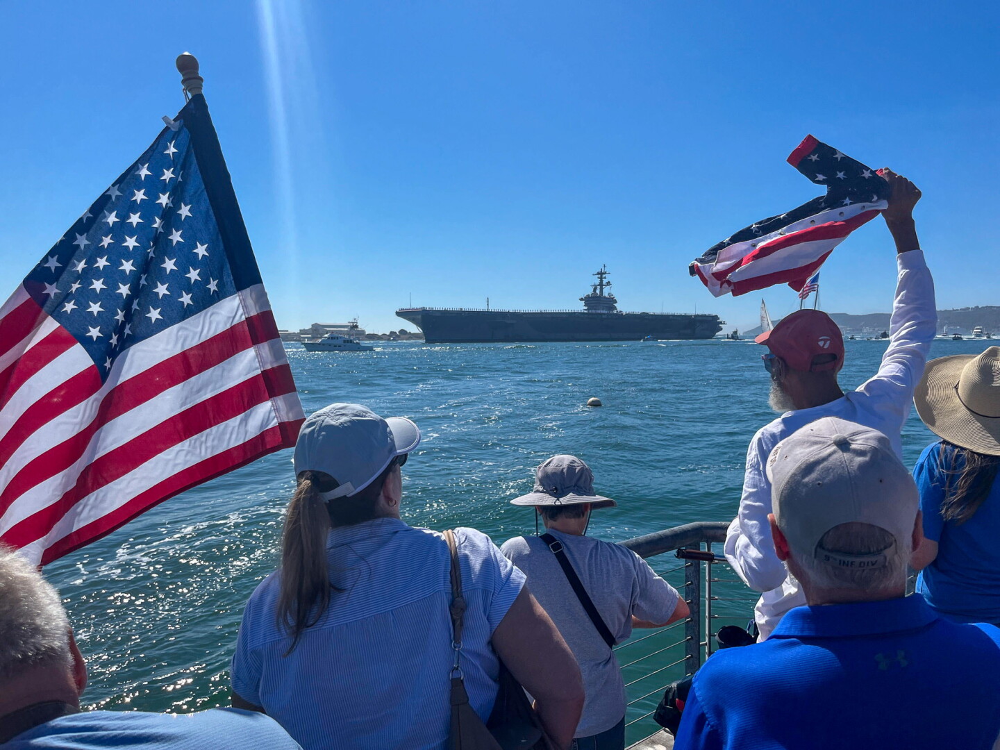 Onlookers gather on Shelter Island to watch the USS Abraham Lincoln return from an extended deployment to the Middle East on Oct. 8, 2026.