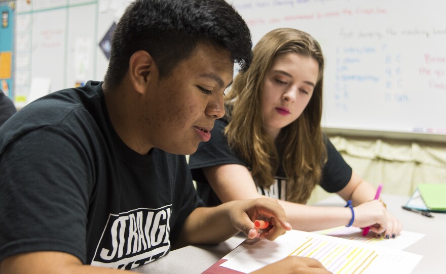 Jose talks with his fellow student Sydnee Outlaw about an assignment for their English class.