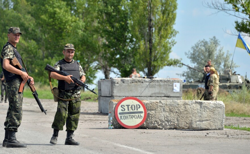 Ukrainian soldiers man a checkpoint about 30 miles from Donetsk, Thursday. Government officials said Friday that a rocket attack had killed as many as 30 soldiers.