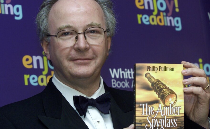 Pullman, author of the <em>His Dark Materials</em> trilogy, holds a copy of its concluding volume, <em>The Amber Spyglass</em>. The first book of a new series will be published in Fall 2017.