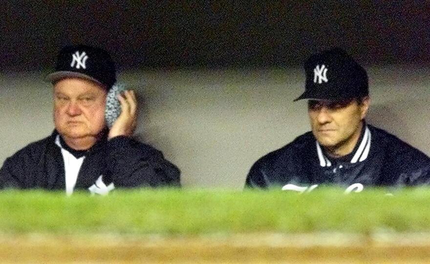 New York Yankees bench coach Don Zimmer holds an ice pack to his head as he sits next to manager Joe Torre. Zimmer had returnd to the bench after being hit bya foul ball. Zimmer, a long-time baseball figure, has died at age 83.