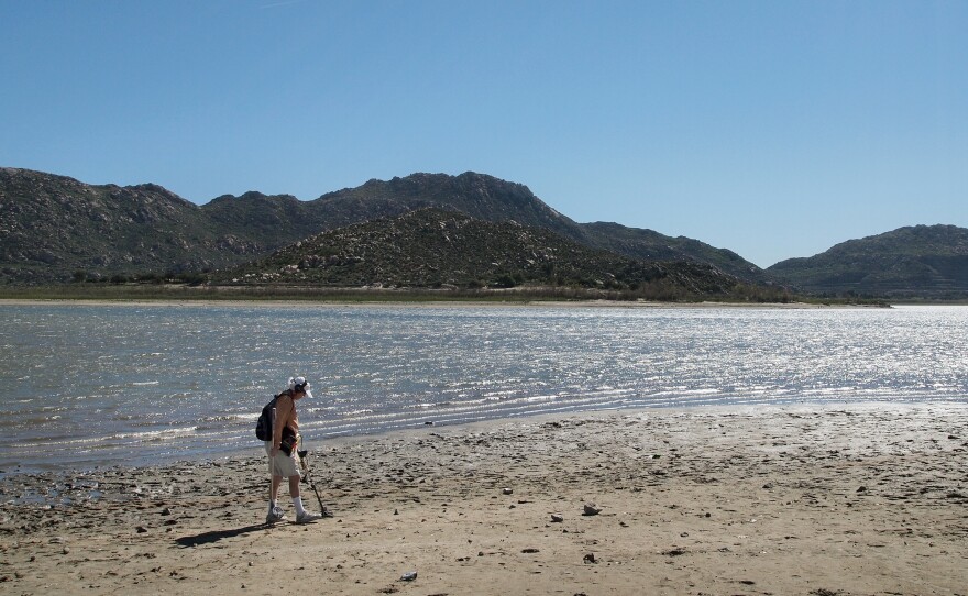 Marty Gabriel, a retired truck driver, passes his metal detector over the exposed sand at California's Lake Perris. Gabriel has been visiting the lake for 25 years. "We definitely need rain," he says.