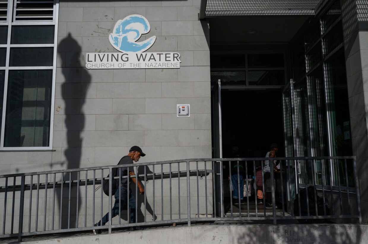 People walk into Living Water Church of the Nazarene, one of four inclement weather shelters for unhoused people in San Diego, on Dec. 20, 2023.