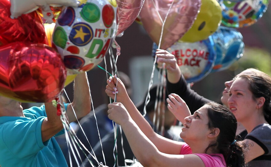 Balloons are placed Tuesday in front of the home of Gina DeJesus in Cleveland. DeJesus was found Monday, along with Amanda Berry and Michelle Knight, after disappearing nine years ago.