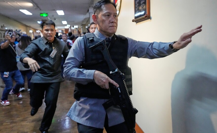 Senate security run after gunfire was heard along a hallway at the Philippine Senate in Pasay, Philippines, Wednesday.