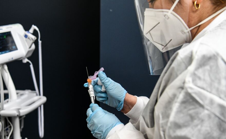 Yaquelin De La Cruz holds a COVID-19 vaccine during clinical trials in August at the Research Centers of America in Hollywood, Fla.