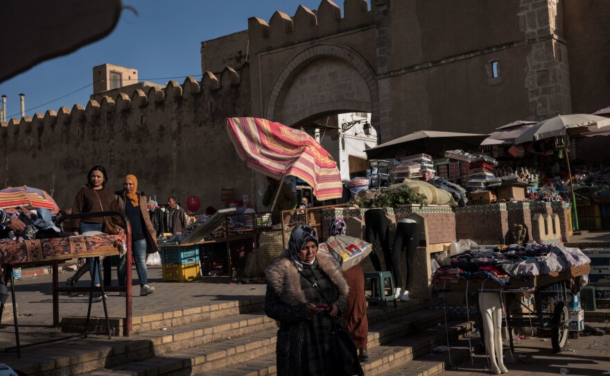 An outdoor market selling produce, household items and second-hand clothing is seen outside the entrance to Sfax. Second-hand sellers have become more common in Tunisia as people haven't been earning enough to buy new goods or are selling their own things.