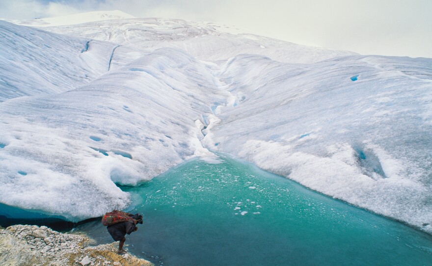 A barefoot porter totes a load for an expedition visiting one of the remaining glaciers near the equator, 16,000 feet high on the highest peak in Papua, Indonesia.