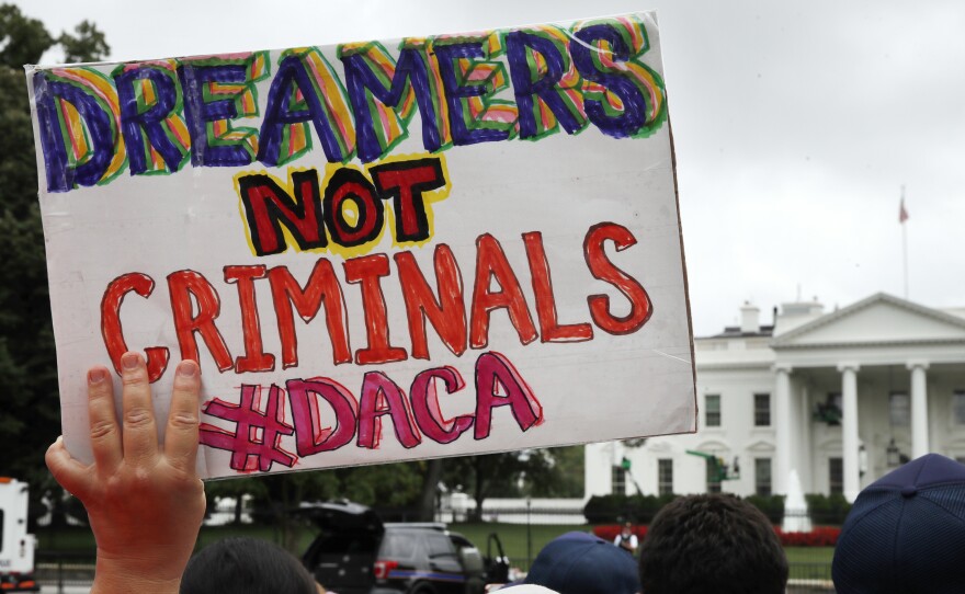 A woman holds up a sign in support of the Obama administration program known as Deferred Action for Childhood Arrivals, or DACA, during a rally at the White House on Aug. 15.