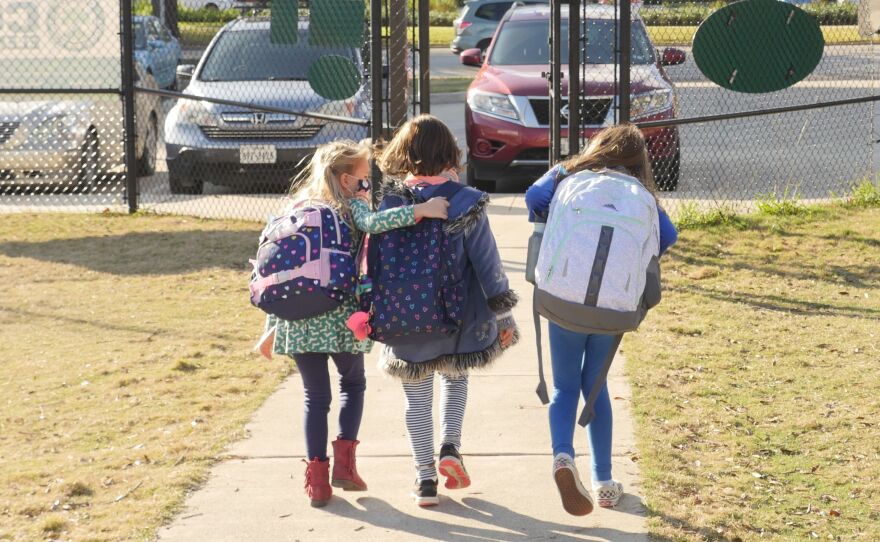 School children wearing facemasks walk outside Condit Elementary School near Houston in December. The U.S. Department of Education announced Friday that it will begin collecting data on the status of in-person learning during the pandemic.