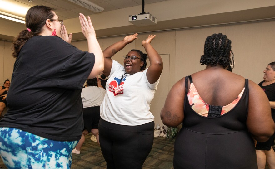 Attendees high-five each other at the end of the 'free the jiggle' wellness class taught by Jessie Diaz-Herrera at Philly FatCon on last month.