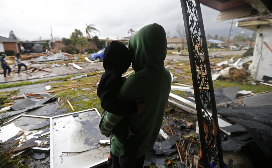 Eshon Trosclair holds her son Camron Chapital on Tuesday after a tornado tore through while they were inside their home in the eastern part of New Orleans. The National Weather Service says at least three confirmed tornadoes touched down, including one inside the New Orleans city limits.