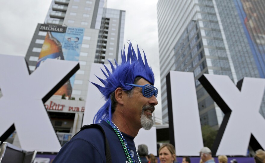 Steve Bronson, from Tempe, Ariz., walks past Roman numerals for the NFL Super Bowl XLIX, on Thursday.