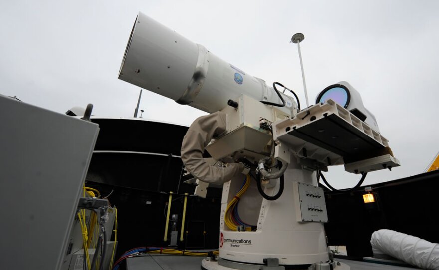  In this July 30, 2012 photo provided by the U.S. Navy, a laser weapon sits temporarily installed aboard the guided-missile destroyer USS Dewey in San Diego. The Navy plans to deploy its first laser on a ship in 2014, and intends to test an electromagnetic rail gun prototype aboard a vessel within the following two years. 