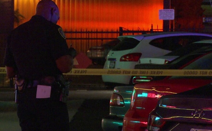 An officer stands at the scene where a man was shot in the Midway District, April 30, 2015.