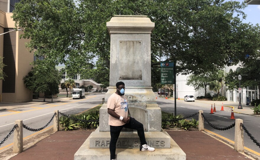 Protest organizer DAntjuan Miller stands by the granite pedestal that remains of a monument to Confederate Navy Adm. Raphael Semmes in Mobile, Ala. "It's like a weight that's lifted off now that it's gone," he says.