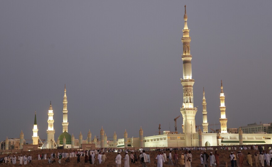 In this July 5, 2013, file photo, worshipers visit the cemetery outside the Prophet's Mosque in Medina, one of Islam's holiest sites. Medina was among the places attacked in Saudi Arabia on Monday.