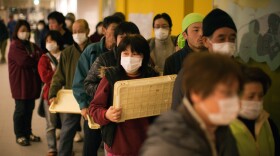 Displaced earthquake victims line up for a meal as hundreds pack a evacuation center MMarch 22, 2011 in Kesennuma, Japan. Eleven days after the magnitude 9 earthquake and tsunami struck Japan that left thousands dead with still many missing. 