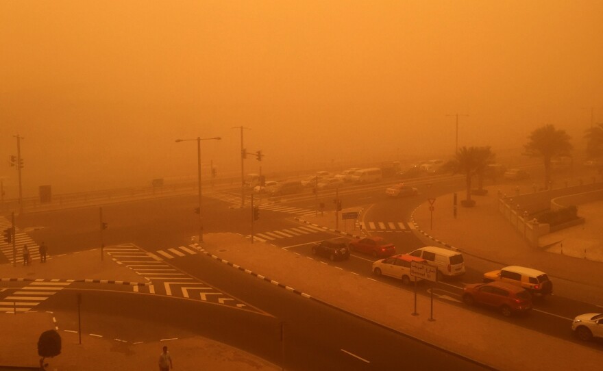 Cars are seen driving Thursday amid a sandstorm that engulfed the city of Dubai, United Arab Emirates.