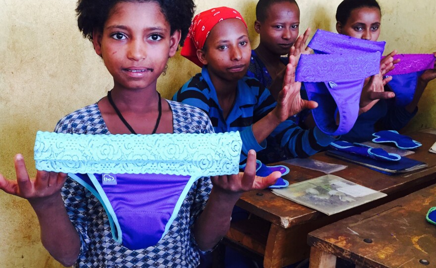Schoolgirls in Ethiopia examine a new feminine product: underwear with a pocket for a menstrual pad.