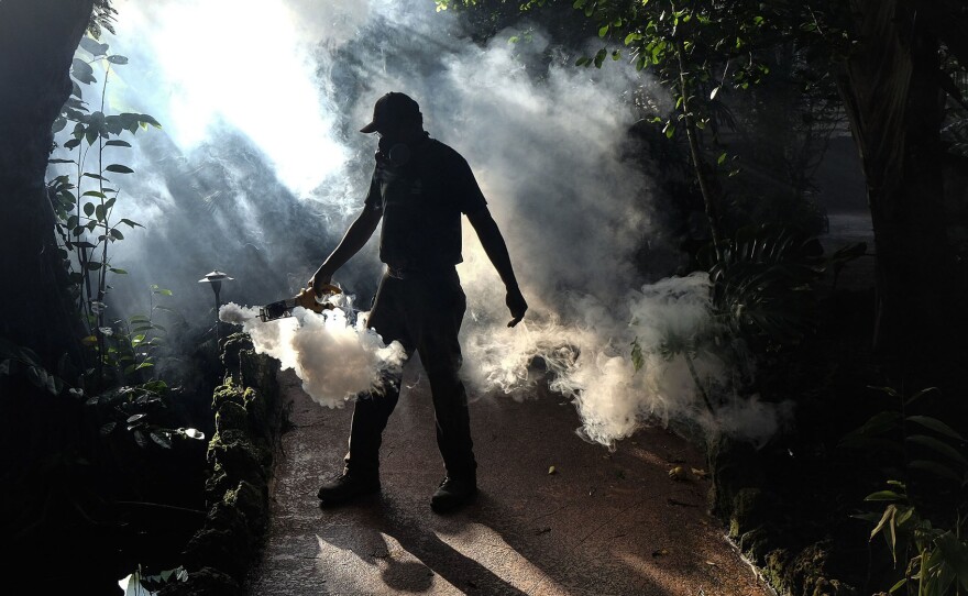 A groundskeeper at Pinecrest Gardens sprays pesticide to kill mosquitoes in Miami-Dade County, Fla., in 2016.