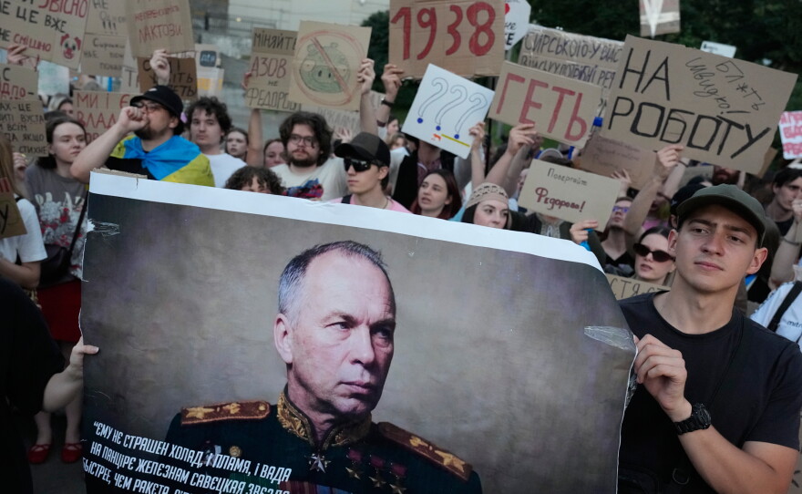 Activists hold a portrait of Ukraine's Armed Forces Commander-in-Chief Oleksandr Syrskyi demanding his resignation during a rally against President Volodymyr Zelenskyy's decision to dismiss Defense Minister Mykhailo Fedorov after six months in the post, in Kyiv, Ukraine, Saturday, July 18.