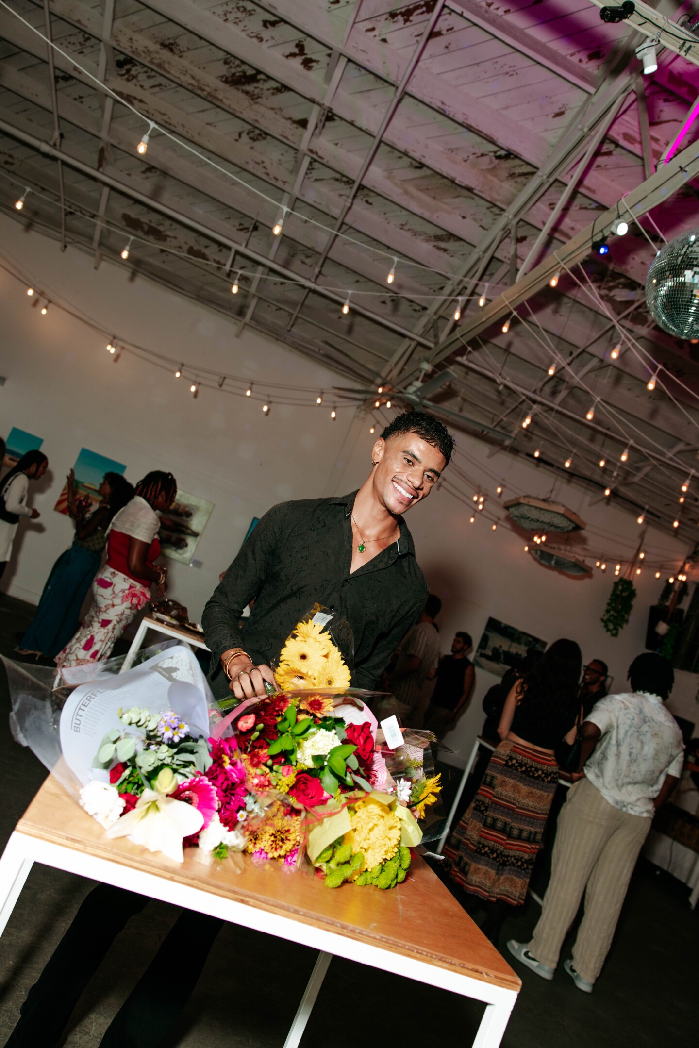 Gillis with flowers he received from loved ones at his first solo art show in San Diego Made Factory on Sept. 28, 2025