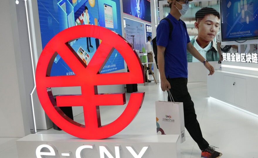 A visitor passes by a logo for the e-CNY, a digital version of the Chinese Yuan, displayed during a trade fair in Beijing, China, on Sept. 5, 2021. China is among a handful of countries that are experimenting with national digital currencies.