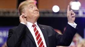 President Donald Trump reacts to the song as he arrives at a rally at the Phoenix Convention Center, Tuesday, Aug. 22, 2017, in Phoenix.