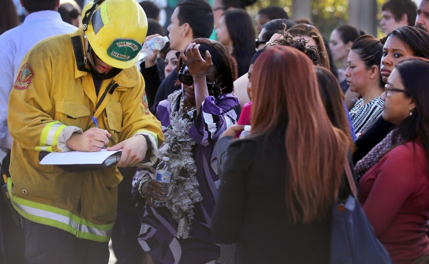 A member of the San Manuel Fire Department takes the names of people being evacuated after the shooting.