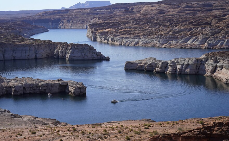 A boat cruises along Lake Powell near Page, Ariz., on July 31, 2021. Seven states in the U.S. West are facing a deadline from the federal government to come up with a plan to use substantially less Colorado River water in 2023.