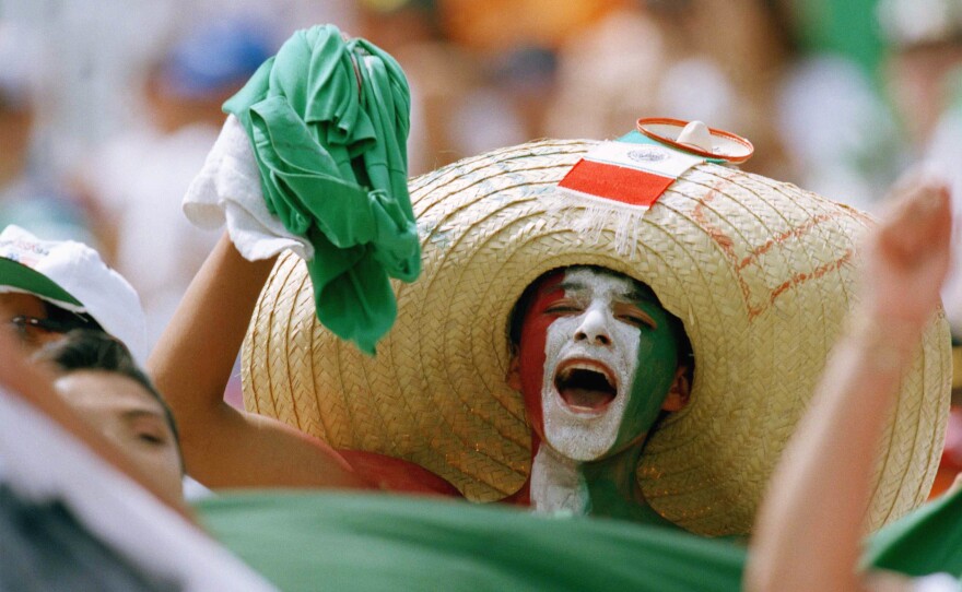 A Mexican fan, his face painted with Mexico's national colors, cheers in the stands at the Citrus Bowl stadium in Orlando, Fla., on June 24, 1994, prior to the start of the World Cup match between Mexico and Ireland.