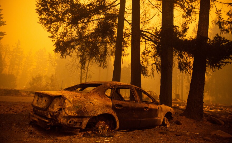 The charred husk of a car remains after the Santiam Fire moved through a neighborhood Wednesday near Gates, Ore.