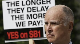 California Gov. Jerry Brown waits to speak a rally to urge lawmakers to approve a plan for a $5 billion-a-year tax and fee road repair measure during a rally Wednesday, April 5, 2017. 