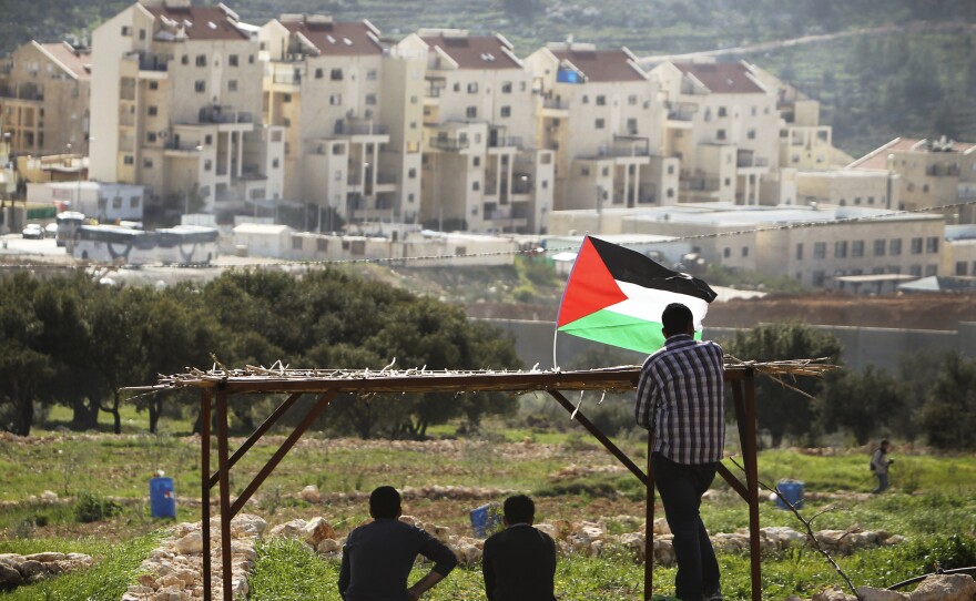 Palestinian protesters look out at the Israeli settlement of Modiin Illit during a demonstration last month in the West Bank town of Bilin, near Ramallah. Both candidates are concerned about their country's relations with the Palestinians.