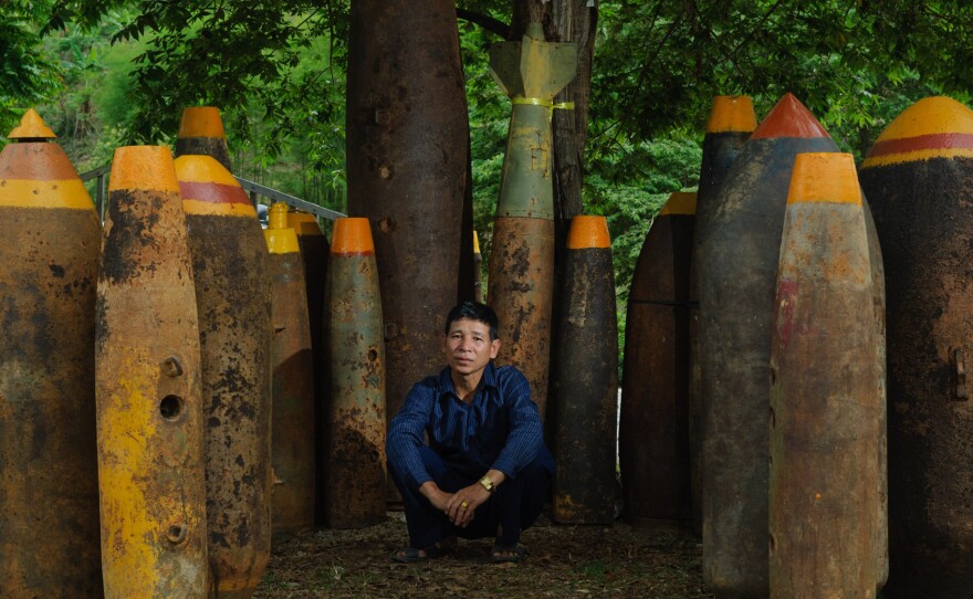 Sang Kham poses amid some of the thousands of bombs he has defused. He's turned the weapons into a shrine to victims of the U.S. bombing campaign.