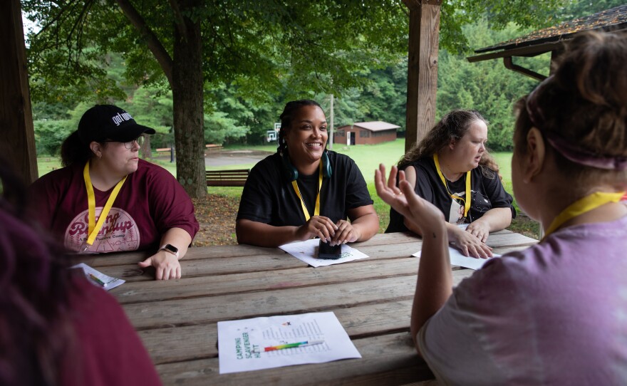 Andrea McAllister, Melissa Reeves and Becky Leach meet with fellow members of Camp Roundup's yellow cabin for the scavenger hunt on Sept. 3.