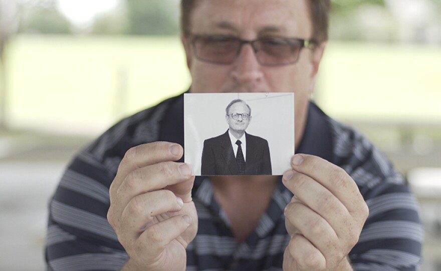 Charles Moore's son, Guy Moore, holds a photo of his father.