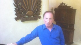Bob Shillman, founder of Cognex Corp., stands next to his family crest in his Rancho Santa Fe home. 