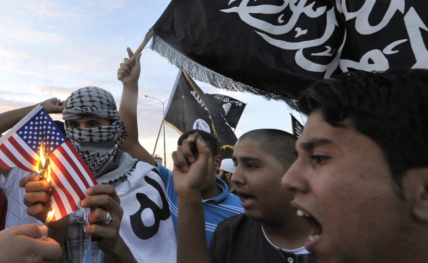 Libyan protesters burn a replica of the U.S. flag on Monday during a demonstration against the capture of Abu Anas al-Libi. U.S. forces seized him Saturday in the Libyan capital Tripoli. He is accused of involvement in two U.S. embassy bombings in Africa in 1998 and is being held on a U.S. Navy ship in the Mediterranean Sea.