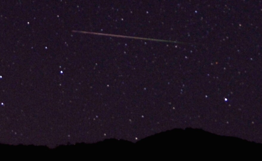 A meteor streaks across the sky north of Castaic Lake, Calif., during last year's Perseid meteor shower. NASA says that tonight's Camelopardalids shower, which has never been seen before, could rival the famous August shower.