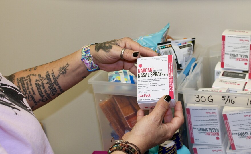Kelly Hans holds a box of Narcan nasal spray at the county's One-Stop Shop in Austin.