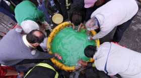 People fill bottles of water from an inflatable pool outside of a fire station in Concepcion on March 1, 2010. 