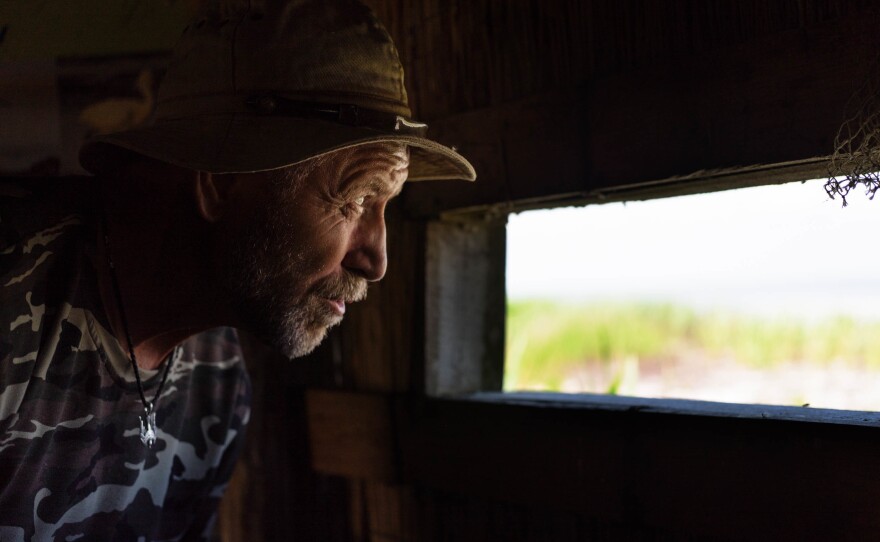 Ivan Rusev, a Bulgarian-born environmentalist and ecologist at Tuzla Lagoons National Nature Park, peers out of a bird-viewing window in a small shack on the lagoon.