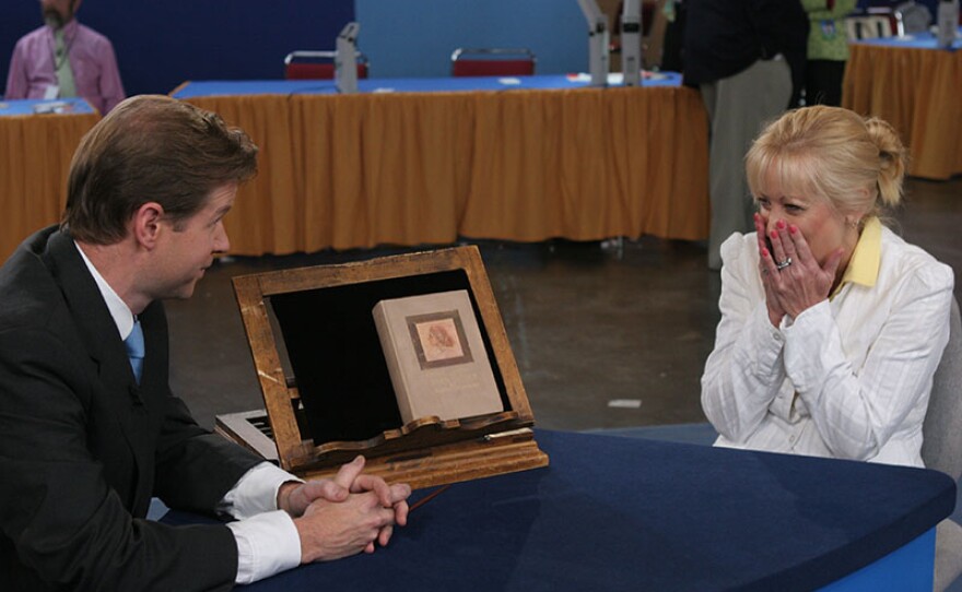 Francis J. Wahlgren (right) appraises a 1908 "Anne of Green Gables" first edition in Providence, R.I.