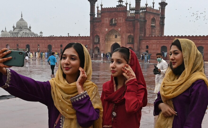 Muslim devotees takes a selfie using their mobile phones after offering special prayers at the historic Badshahi Mosque in Lahore, Pakistan.