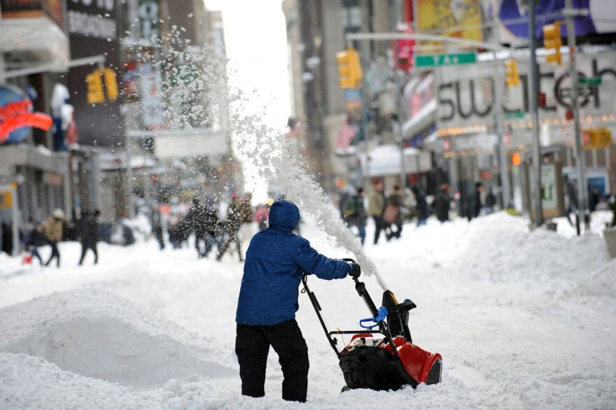 A man uses a snowblower to clear a street Monday in New York City's Times Square after a blizzard dropped 20 inches of snow in the area.